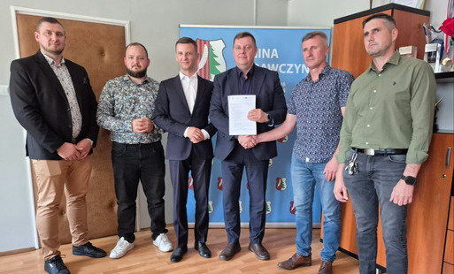 Wójt oraz radni na pamiątkowym zdjęciu z wykonawcami